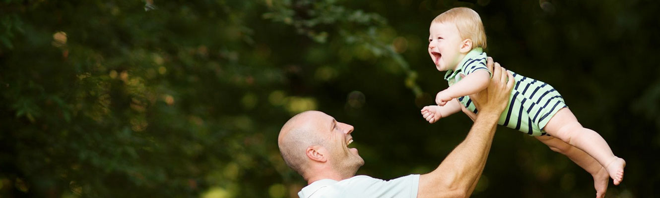smiling-father-holds-laughing-boy-toddler-in-the-air
