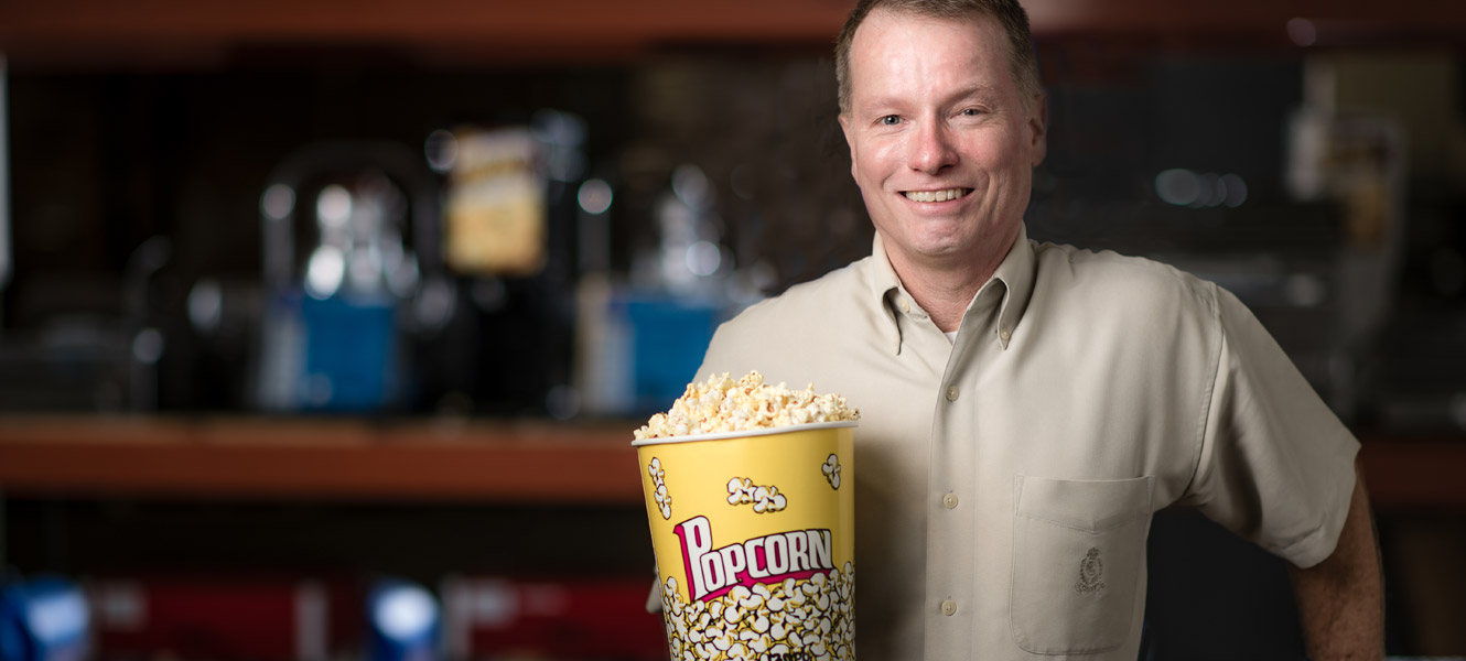 Fred Blank in Tr-State Theatre's warehouse holding a bucket of popcorn