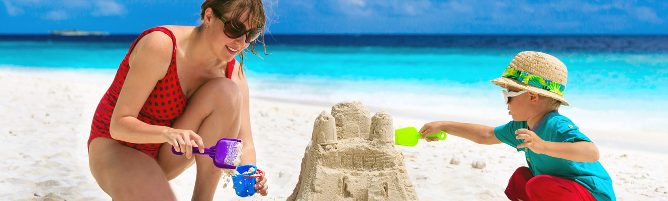 mother and child building sand castle on the beach