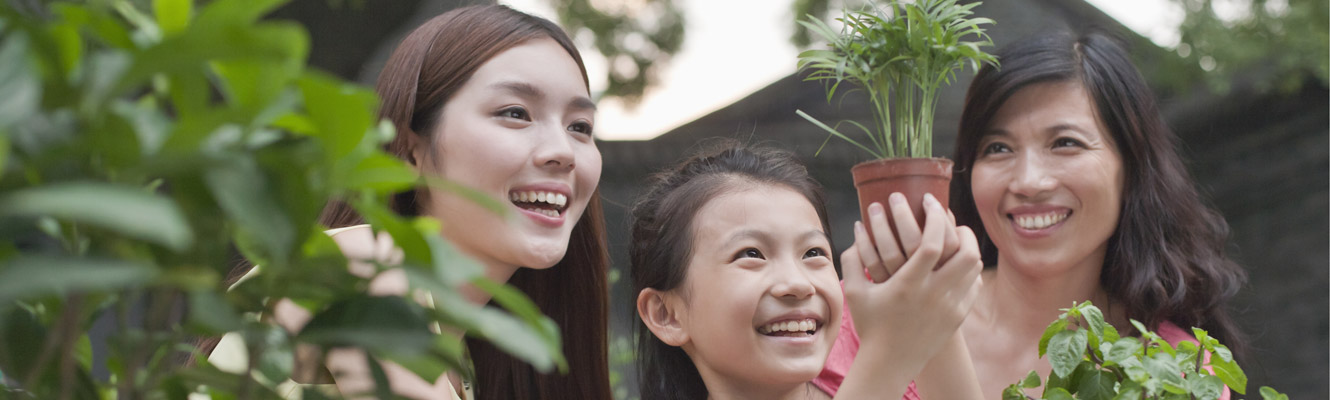 3 girls in garden studying a plant