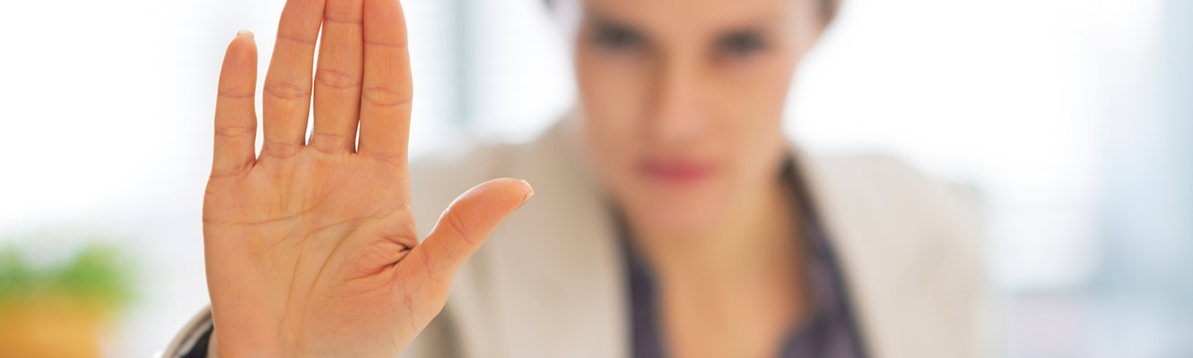 Woman holding out hand signaling halt.