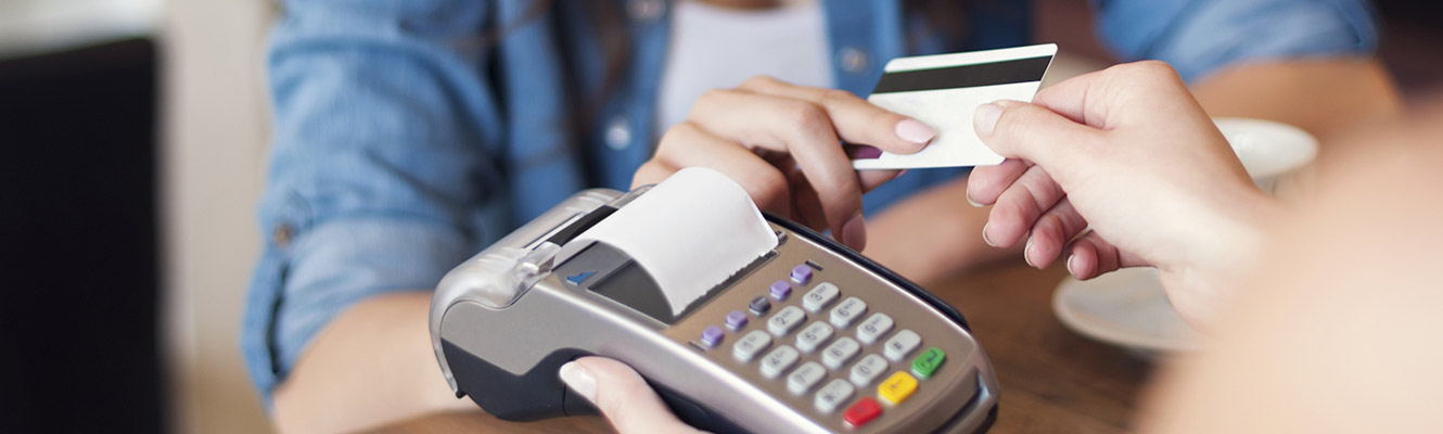 Woman handing card for payment to business worker.