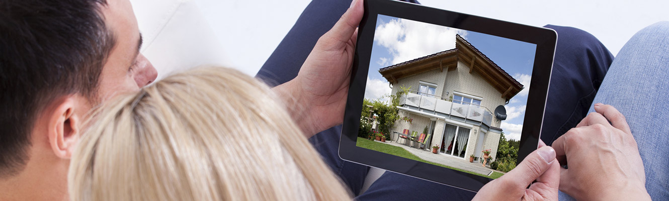 Couple looking at houses on a tablet.