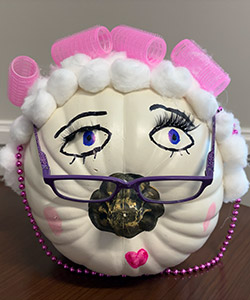 Pumpkin entry #3 - white pumpkin decorated to look like an old lady with white cotton balls for the hair and pink curlers, glasses and pink-purple necklace.