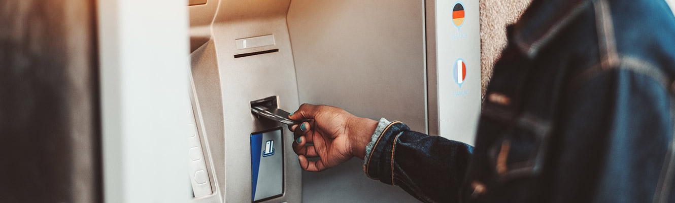 Lady using ATM card at ATM machine