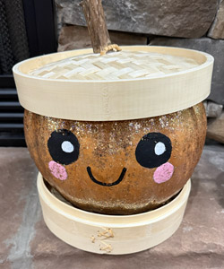 Pumpkin entry #6 - painted cute black eyes and rosy cheeks - cute little smile. It sits on something to look like a collar and the pumpkin is wearing a woven top to look like a sailor cap.